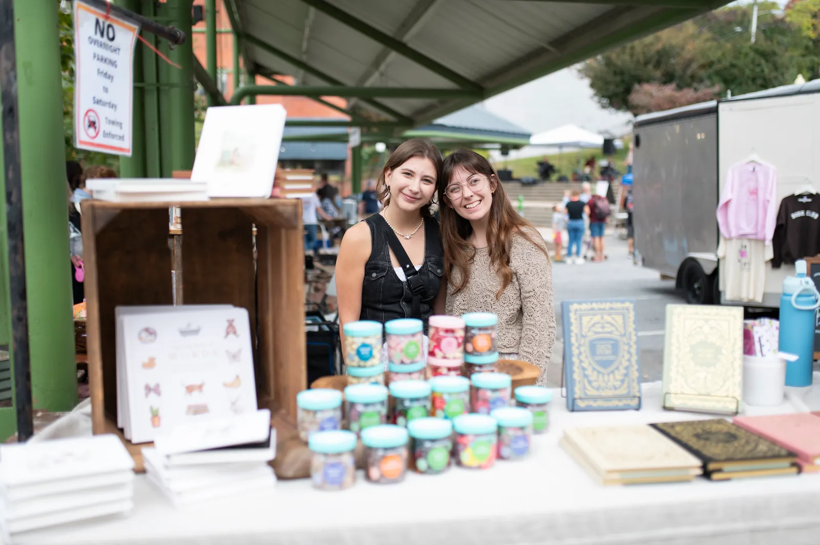 Vendors at a Books & Brews booth with books and handmade candles