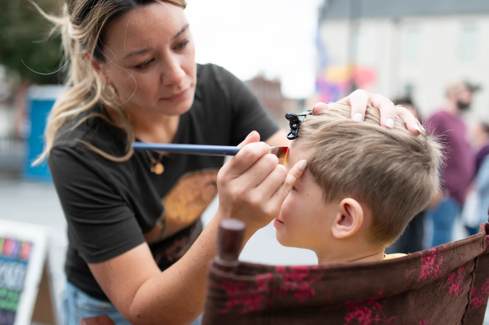 A child getting their face painted at Books & Brews