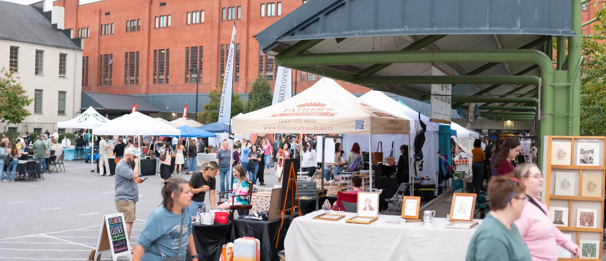 Vendor tents and crowds filling the Lynchburg Community Market during Books & Brews