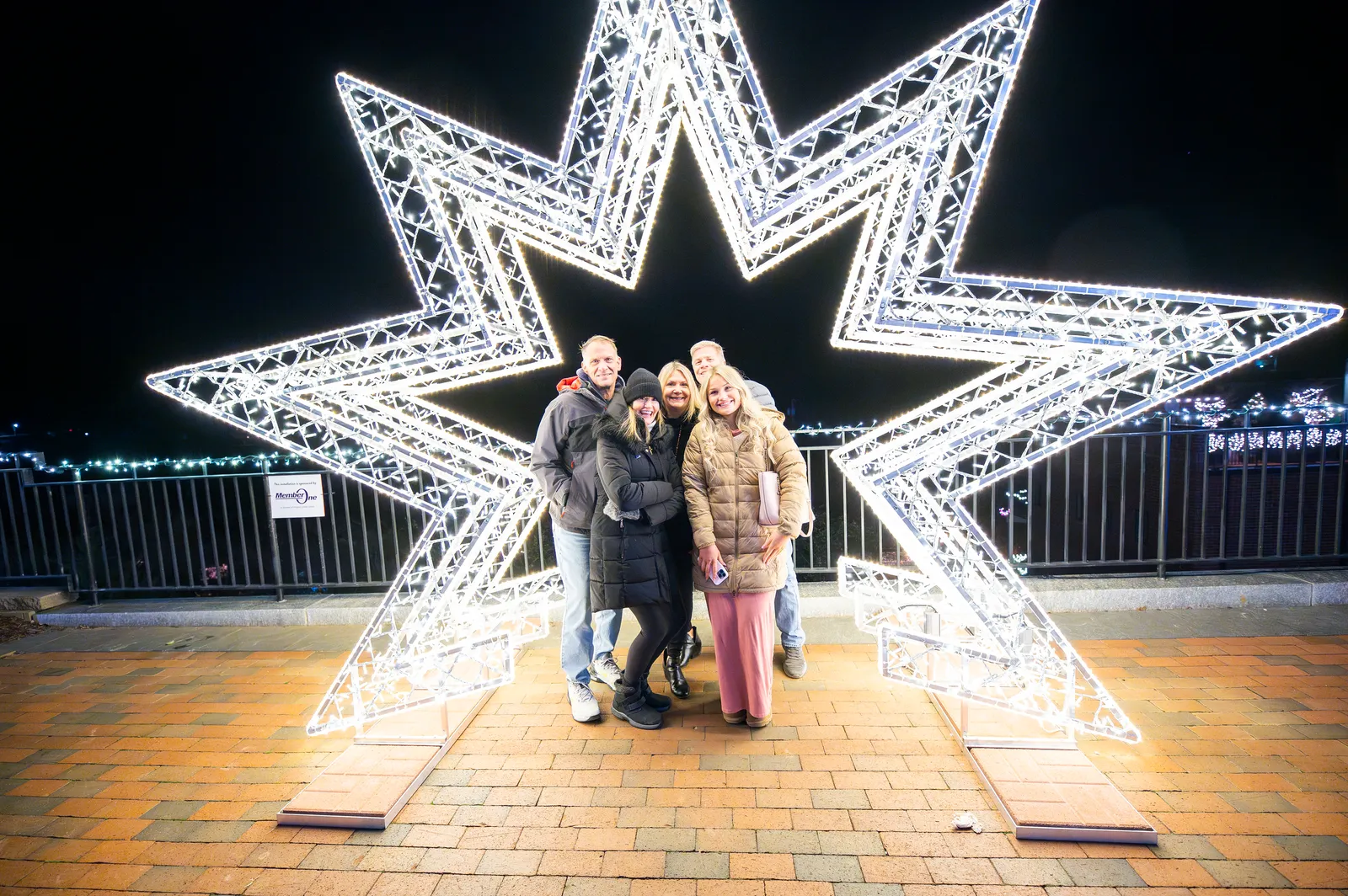 A family posing inside a giant illuminated star on the Bluffwalk